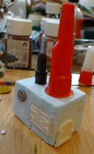 Le bloc moteur : une machine à vapeur à base de bouchons de colle, de petits boucliers et d'éléments Hirst art.